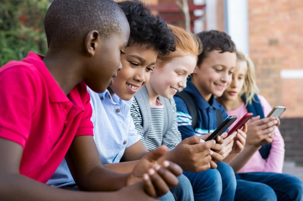 group of young kids looking at cellphones