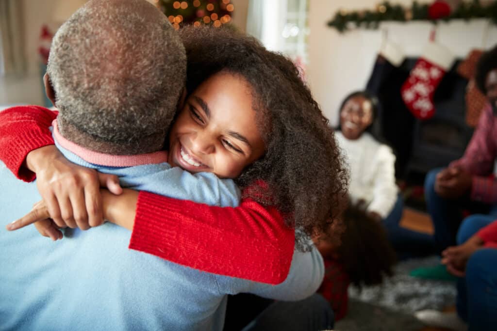 little girl smiling hugging her grandpa