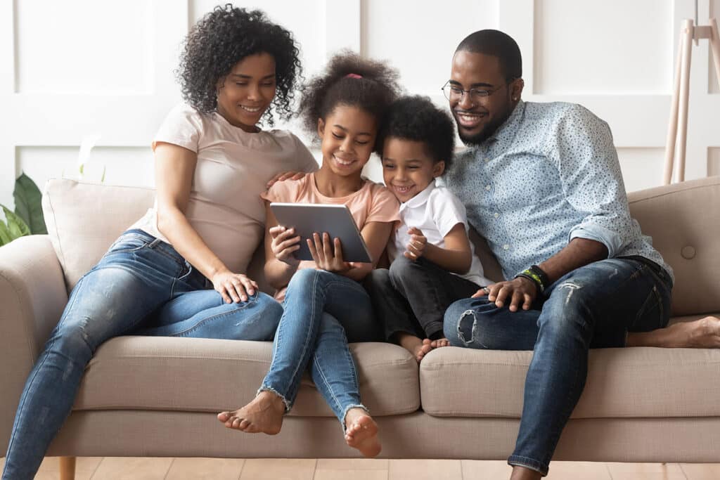 family looking at tablet on couch