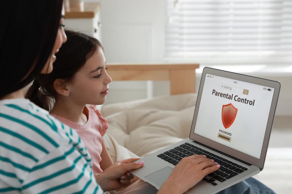 mother and daughter looking at parental control on laptop