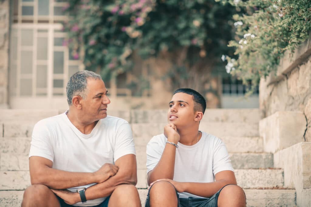 father and son talking on stone steps