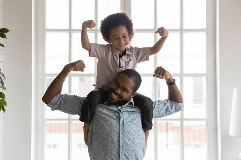 father and son smiling and flexing